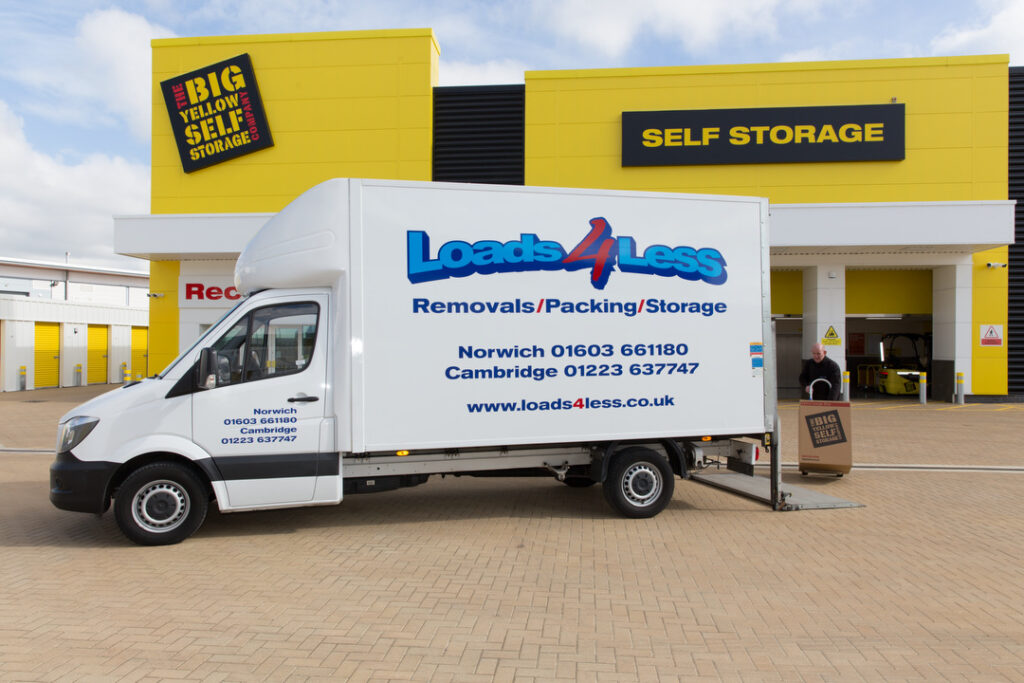 About us Image of Luton removals van with employee loading items onto tail lift. 