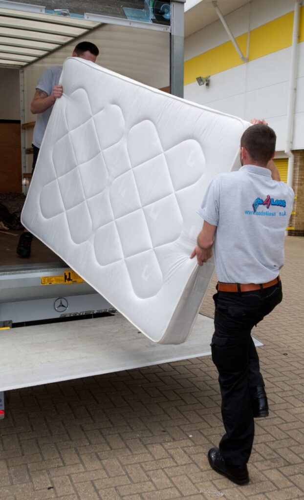 Two Loads4Less removals staff loading a mattress into a Luton using tail lift.