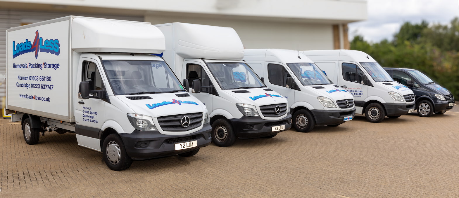 Landscape image of Loads4Less fleet Luton vehicle far left following down with sprinter vehicles and finally Mercedes vito vehicle.