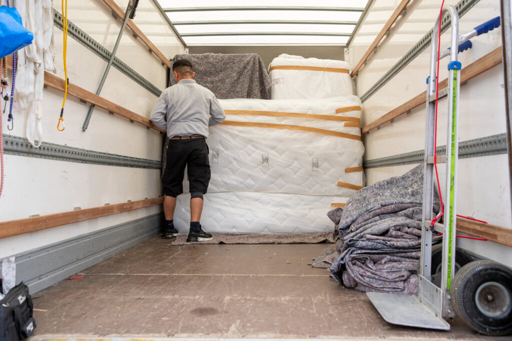 Walid one of our van man staff. Fastening a mattress back for a customer inside a Luton tail lift van.